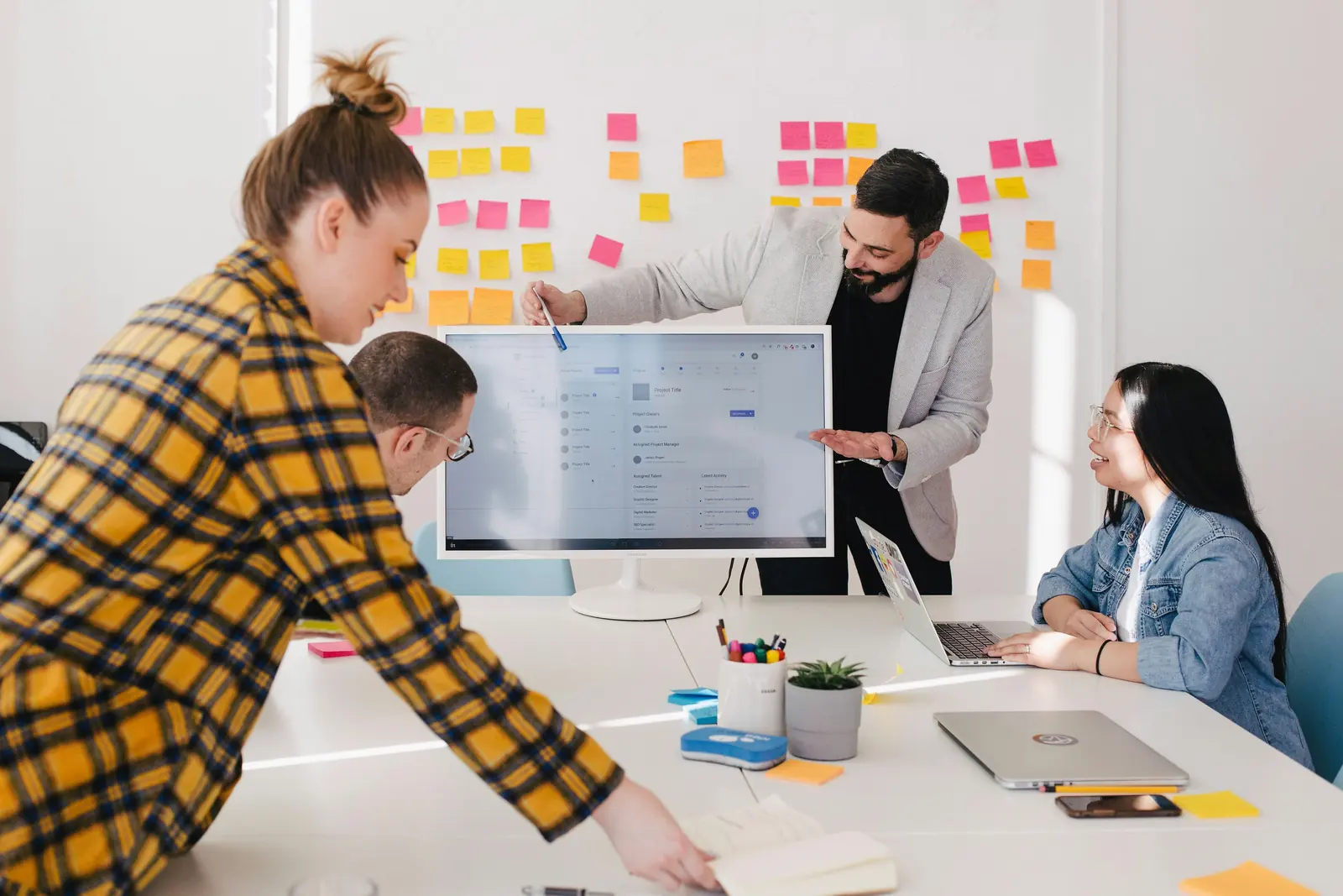 A team planning at a whiteboard covered in sticky notes